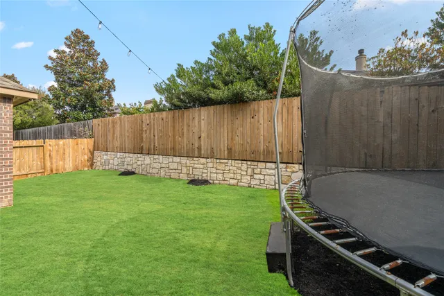 a view of a backyard with wooden fence