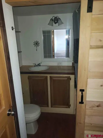 a bathroom with a sink a toilet a mirror and vanity