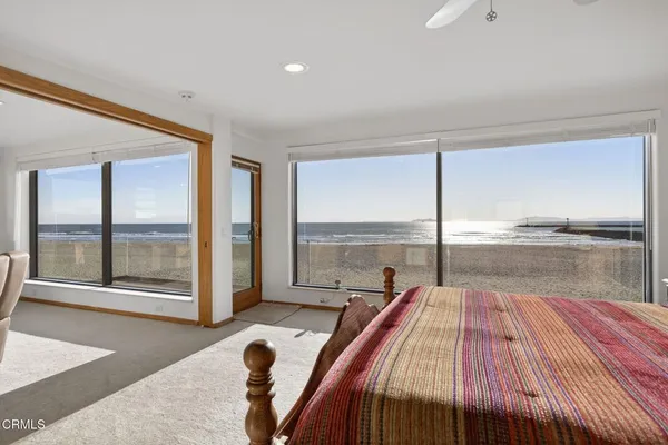 a bedroom with a bed and large windows