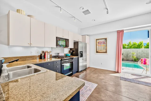 a kitchen that has a sink and a stove top oven
