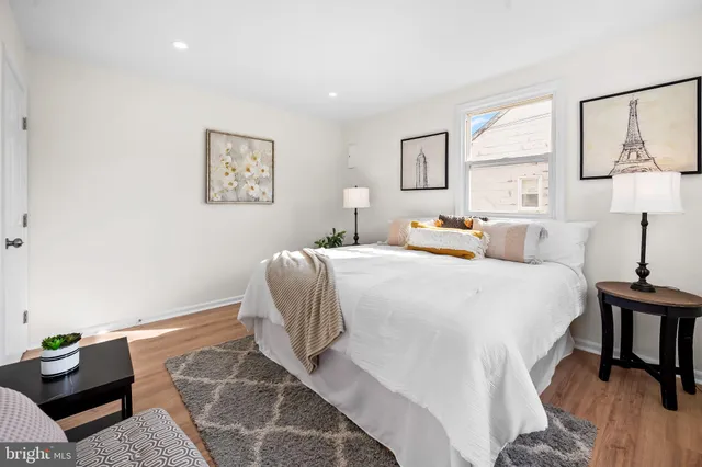 a bedroom with a bed and a lamp on dresser