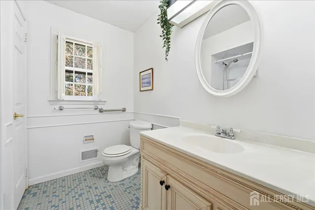 a bathroom with a sink a mirror a toilet and a window