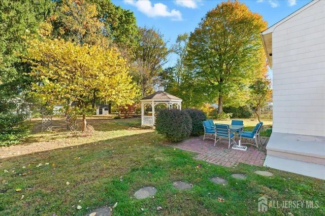 a view of a backyard with table and chairs and a tree