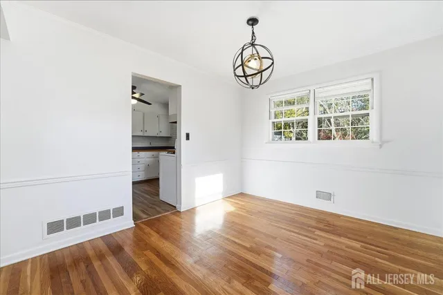 a view of empty room with wooden floor and window
