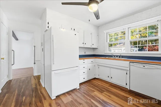 a kitchen with granite countertop white cabinets and white appliances