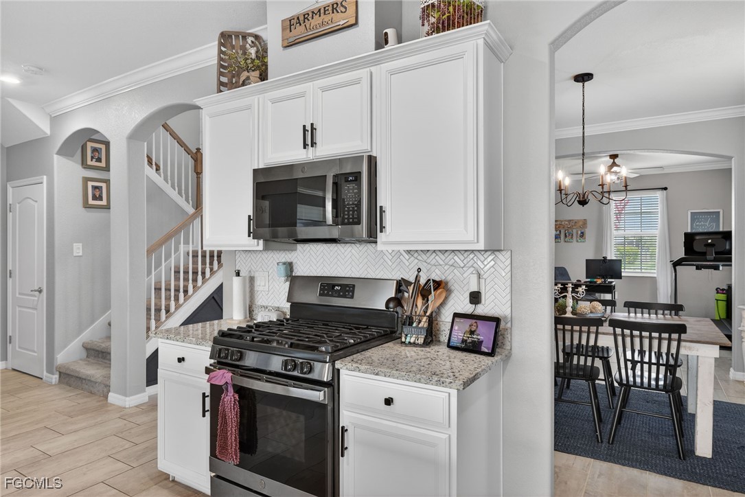 43325 Waymark Place Punta Gorda, FL 33982 - Photo 17 of 49 a kitchen with stainless steel appliances granite countertop a stove a sink and a microwave