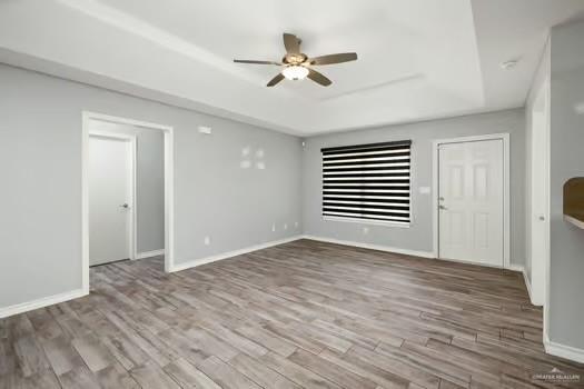 1403 Tierra Rica Avenue Alamo, TX 78516 - Photo 4 of 13 a view of an empty room with wooden floor and a ceiling fan