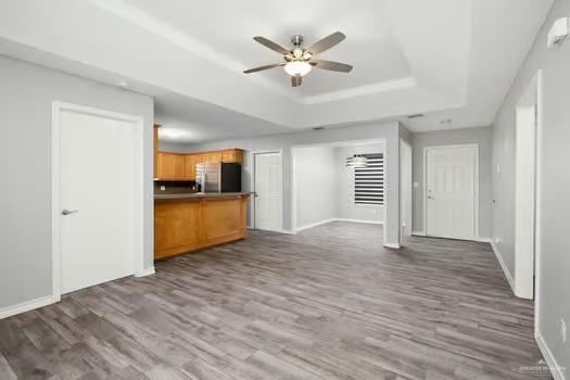 1403 Tierra Rica Avenue Alamo, TX 78516 - Photo 5 of 13 a view of a livingroom with a ceiling fan a kitchen space with wooden floor and a ceiling fan