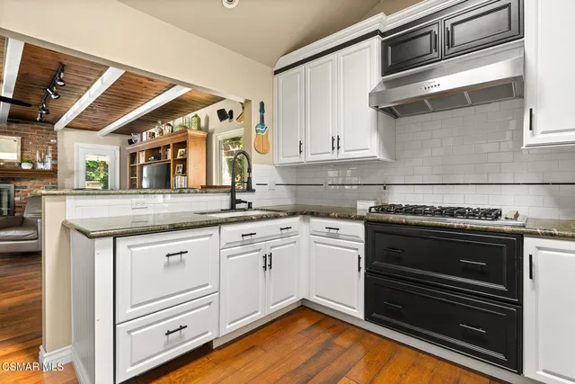 a kitchen with granite countertop stainless steel appliances and white cabinets