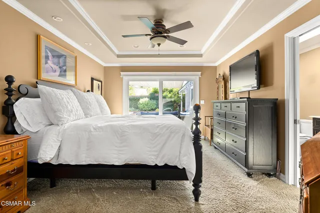 a spacious bedroom with a bed and a television