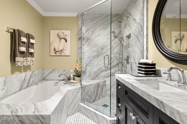 a bathroom with a granite countertop sink a mirror a vanity and bathtub