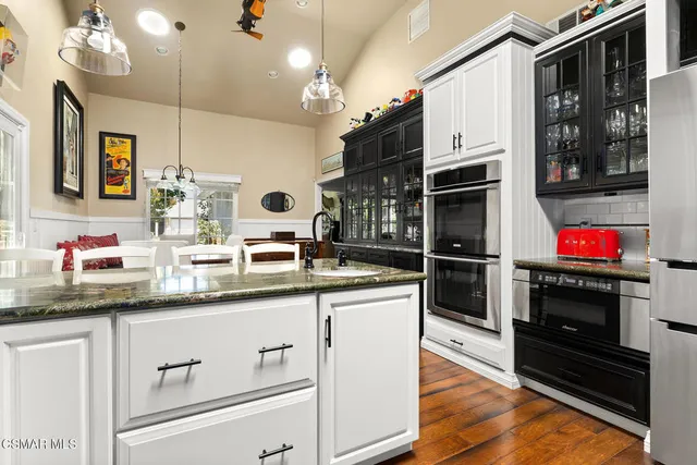 a kitchen with stainless steel appliances granite countertop a sink and a stove