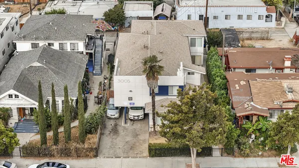 an aerial view of residential houses with outdoor space and parking