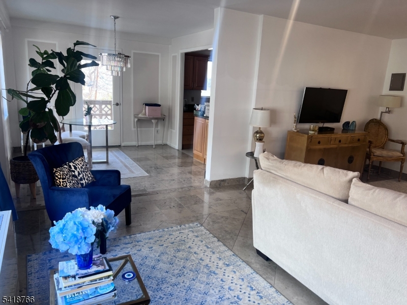 1375 River Road, Unit 2K Edgewater, NJ 07020 - Photo 4 of 13 a living room with furniture flowerpot and a chandelier