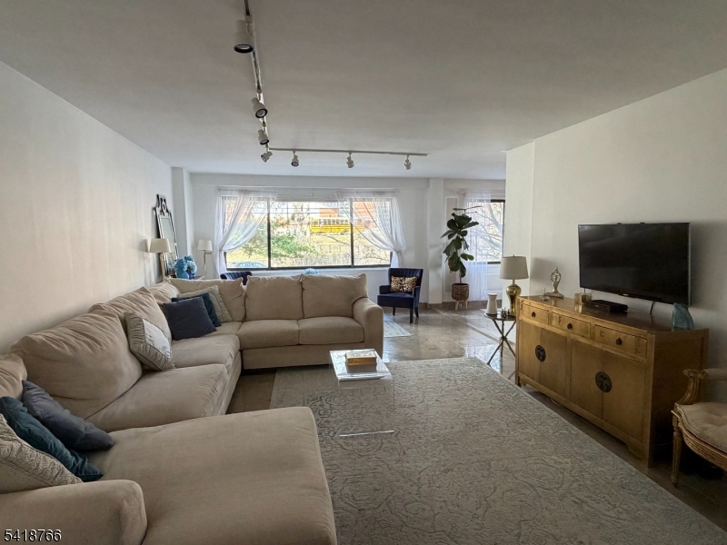 1375 River Road, Unit 2K Edgewater, NJ 07020 - Photo 6 of 13 a living room with furniture and a flat screen tv