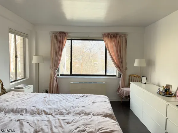 a bedroom with a bed and large windows