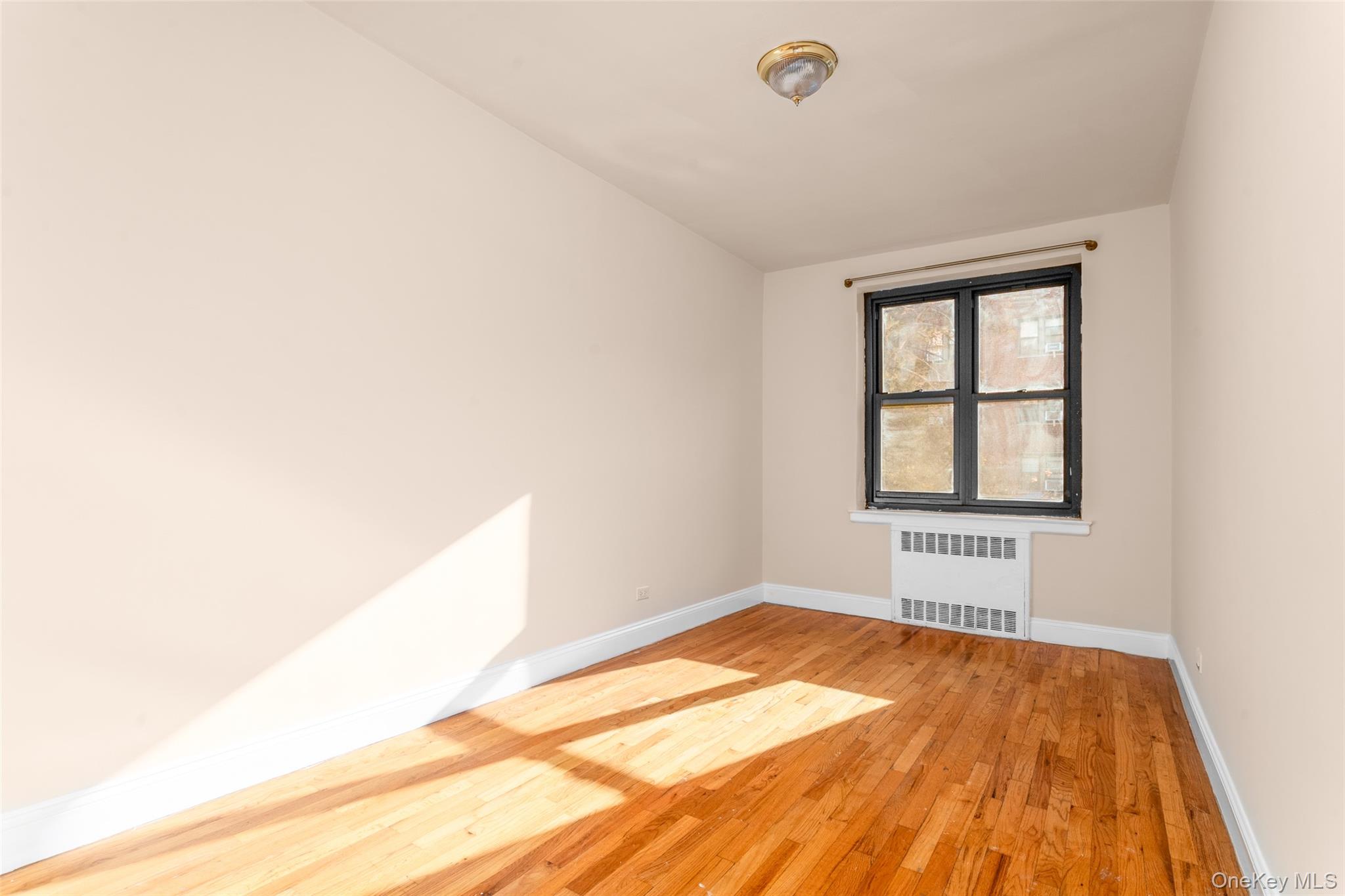 100-11 67th Road, Unit 205 Forest Hills, NY 11375 - Photo 7 of 15 a view of empty room with wooden floor and fan