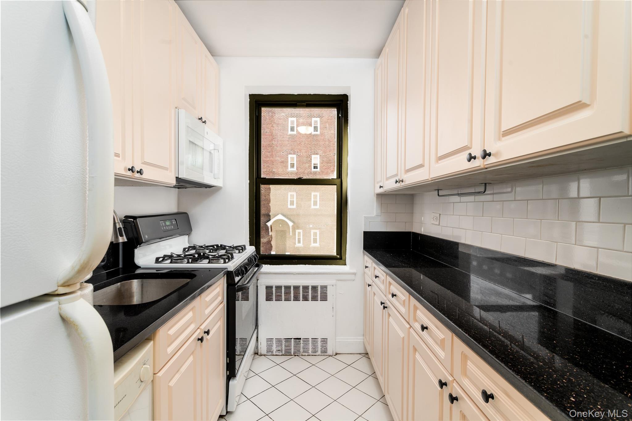 100-11 67th Road, Unit 205 Forest Hills, NY 11375 - Photo 8 of 15 a kitchen with granite countertop a stove sink and cabinets