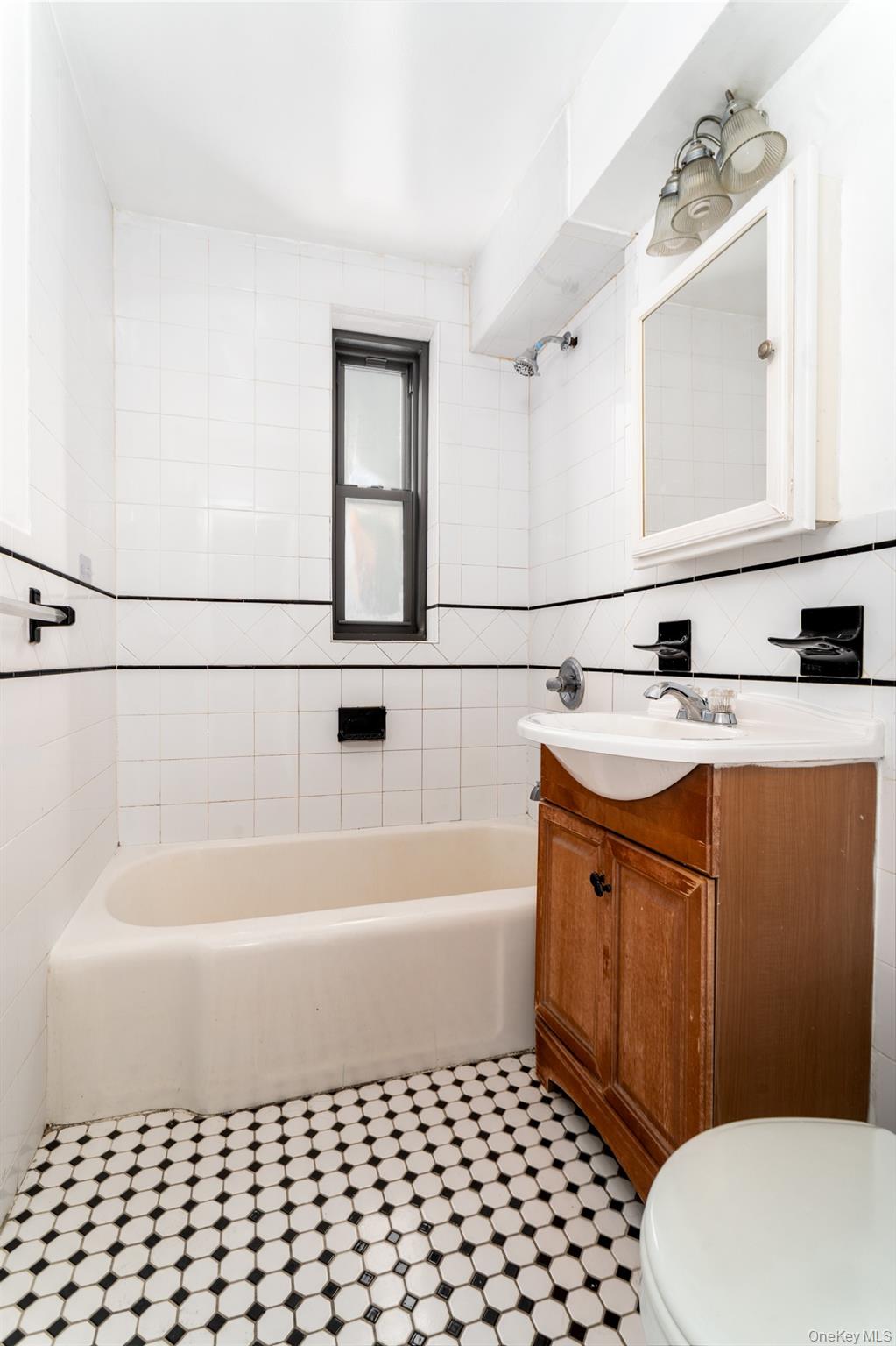 100-11 67th Road, Unit 205 Forest Hills, NY 11375 - Photo 9 of 15 a bathroom with a sink a toilet a mirror and shower