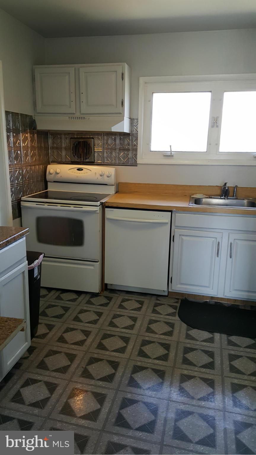 1008 Collwood Road Catonsville, MD 21228 - Photo 2 of 25 a kitchen with a stove and white cabinets