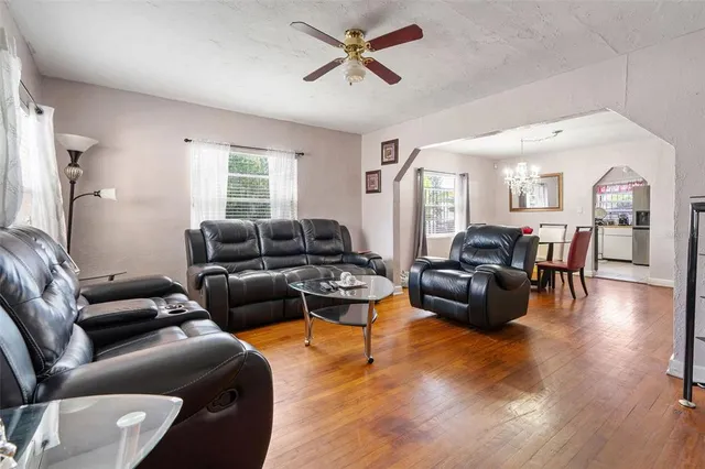 a living room with furniture wooden floor and a large window