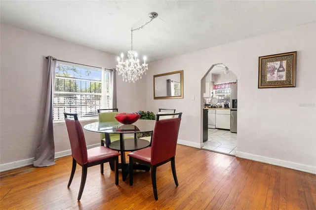 a dining room with furniture a chandelier and wooden floor
