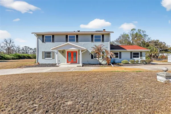 a view of an empty room with wooden floor and stairs