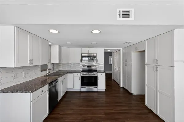 a kitchen with stainless steel appliances granite countertop a sink and stove top oven