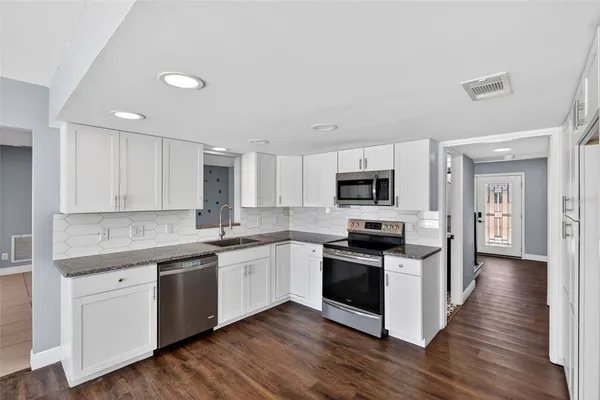 a kitchen with a sink stove and cabinets
