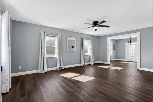 a view of empty room with wooden floor and window