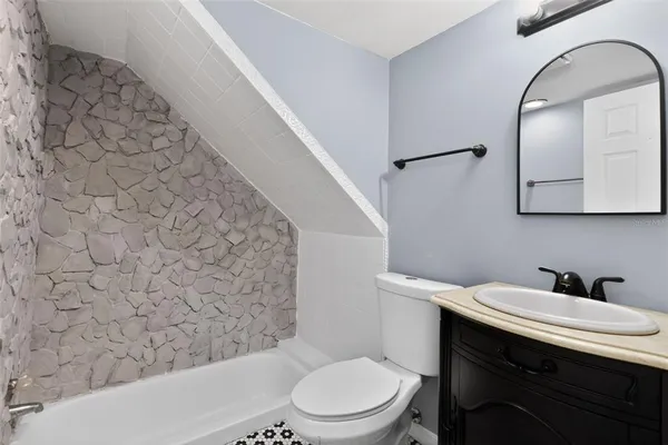 a bathroom with a tub sink and mirror