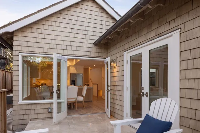 a view of a porch with a table and chairs and floor to ceiling window