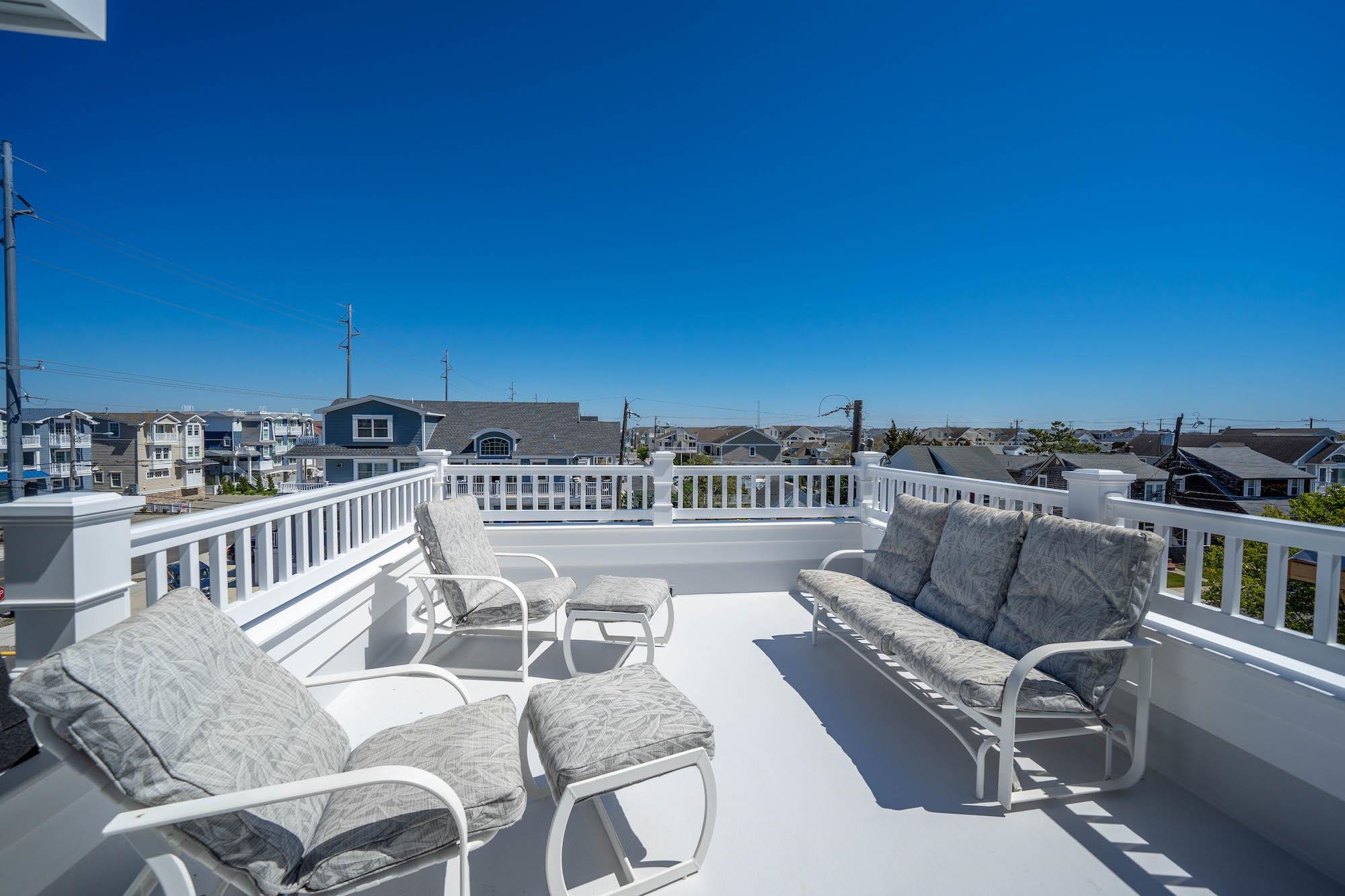 280 36th Avalon, NJ 08202 - Photo 36 of 46 a view of a patio with couches table and chairs with wooden floor