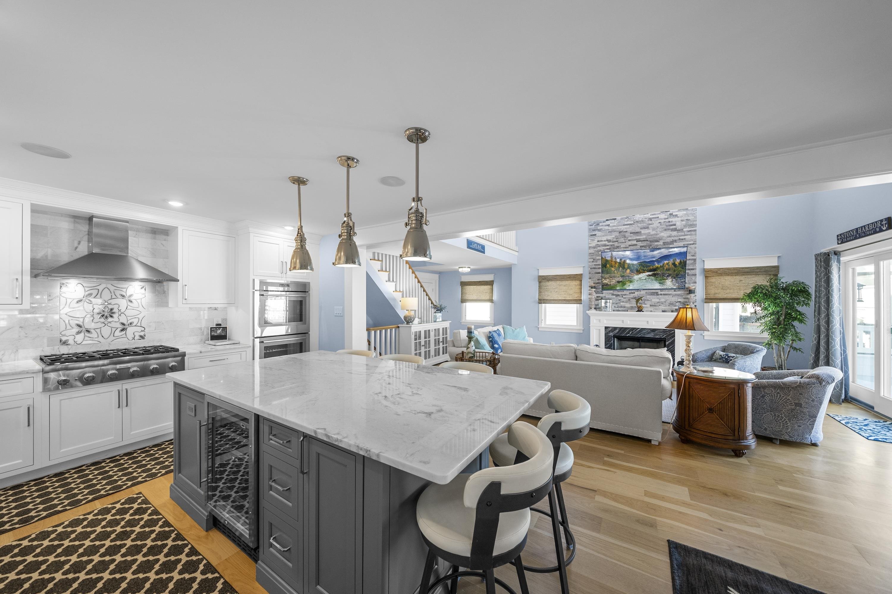 280 36th Avalon, NJ 08202 - Photo 8 of 46 a kitchen with stainless steel appliances granite countertop a table chairs stove a sink dishwasher and cabinets