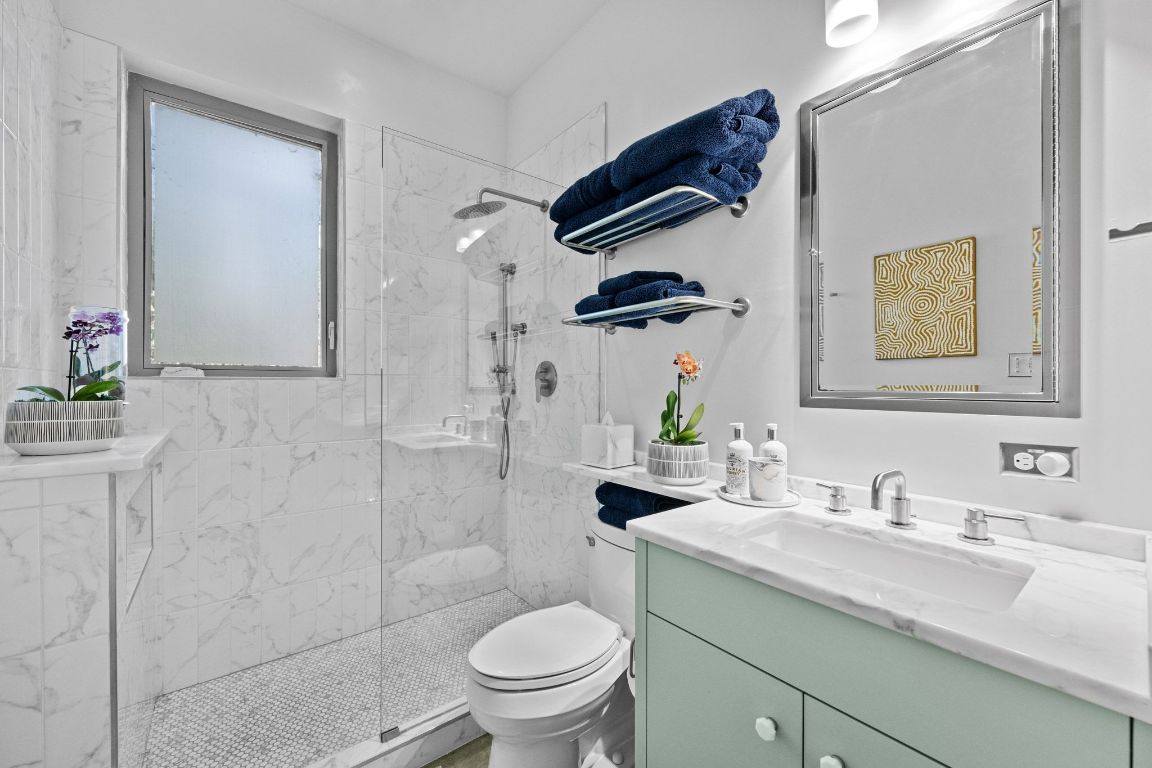 3705 Bridle Path Austin, TX 78703 - Photo 15 of 26 a bathroom with a granite countertop sink a toilet and shower