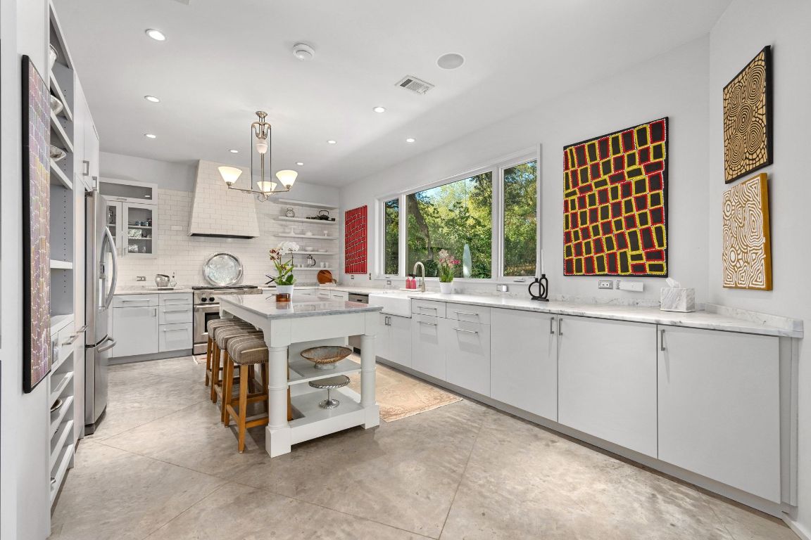 3705 Bridle Path Austin, TX 78703 - Photo 7 of 26 a kitchen with kitchen island granite countertop a sink and a stove top oven