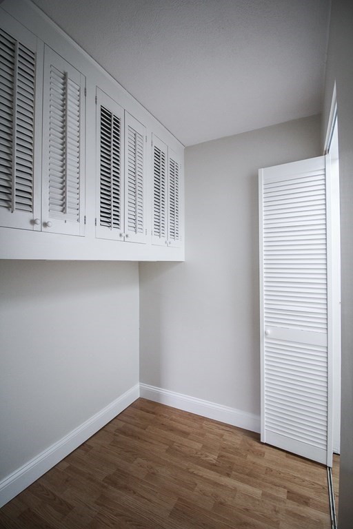 272 Albion Street, Unit 23 Wakefield, MA 01880 - Photo 25 of 33 an empty room with wooden floor and cabinet