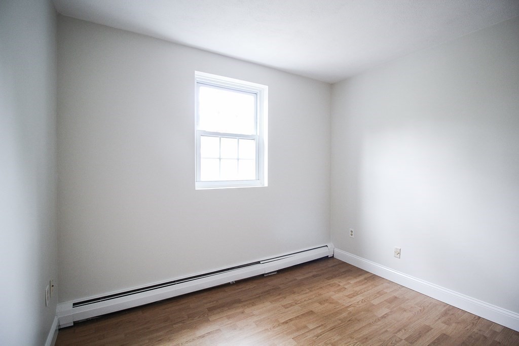 272 Albion Street, Unit 23 Wakefield, MA 01880 - Photo 30 of 33 an empty room with wooden floor and windows