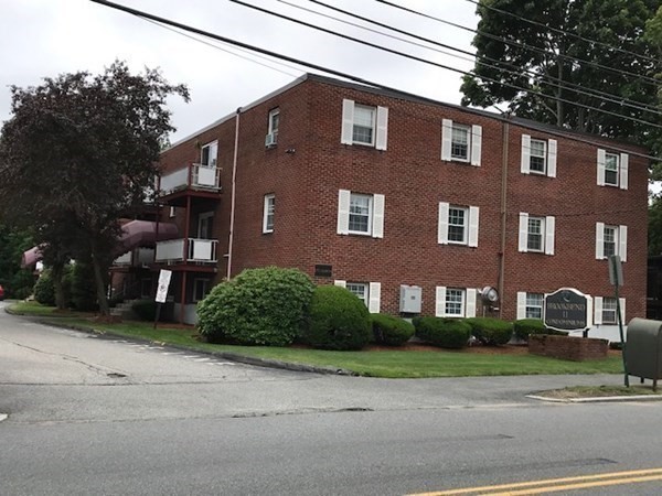 272 Albion Street, Unit 23 Wakefield, MA 01880 - Photo 32 of 33 a front view of a house with a yard and garage