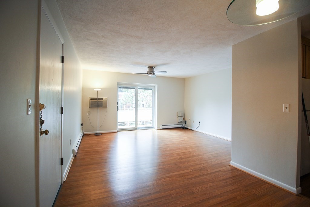 272 Albion Street, Unit 23 Wakefield, MA 01880 - Photo 5 of 33 a view of an empty room with wooden floor and a window