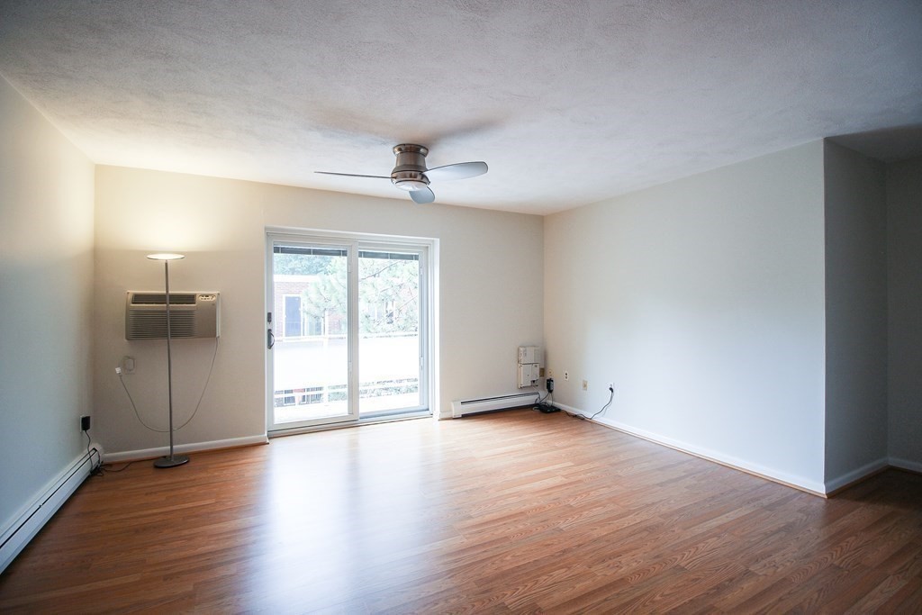 272 Albion Street, Unit 23 Wakefield, MA 01880 - Photo 6 of 33 a view of an empty room with wooden floor and a window