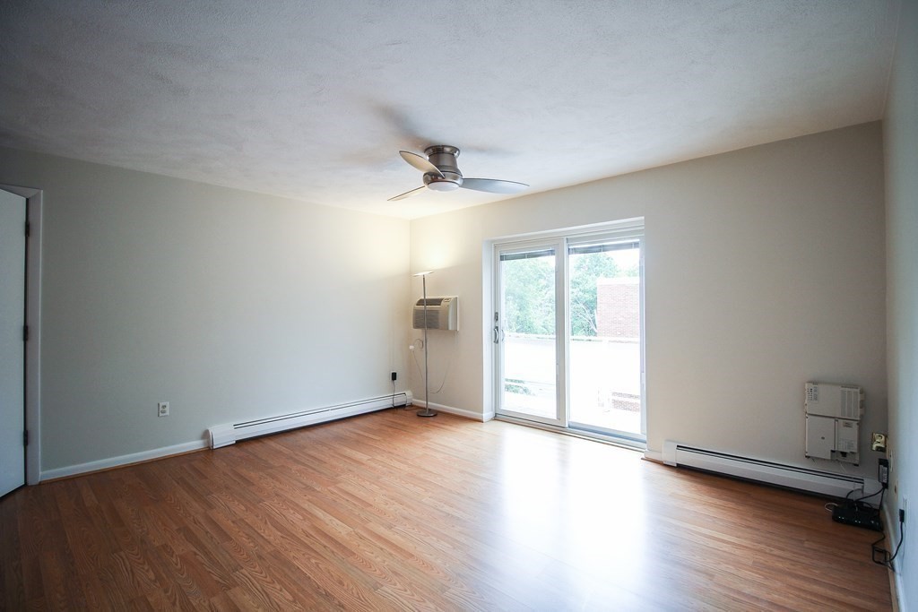 272 Albion Street, Unit 23 Wakefield, MA 01880 - Photo 7 of 33 an empty room with wooden floor and windows