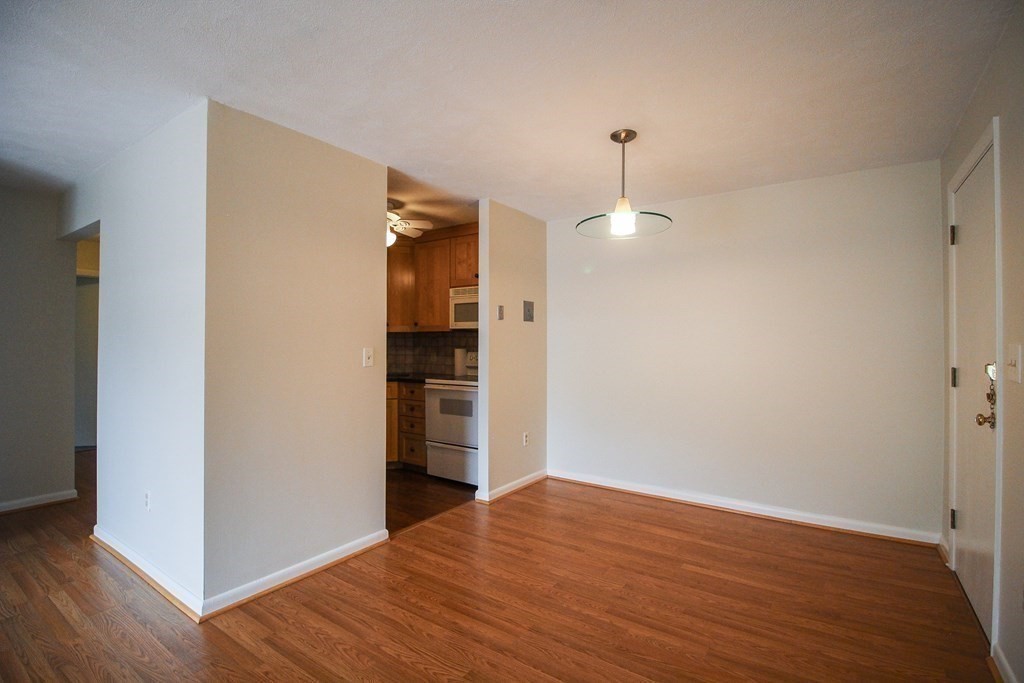272 Albion Street, Unit 23 Wakefield, MA 01880 - Photo 9 of 33 a view of empty room with wooden floor and ceiling fan