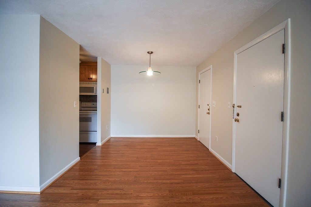 272 Albion Street, Unit 23 Wakefield, MA 01880 - Photo 10 of 33 a view of an empty room with wooden floor and a window