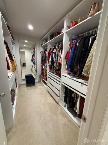 a view of walk in closet with clothes and shoes