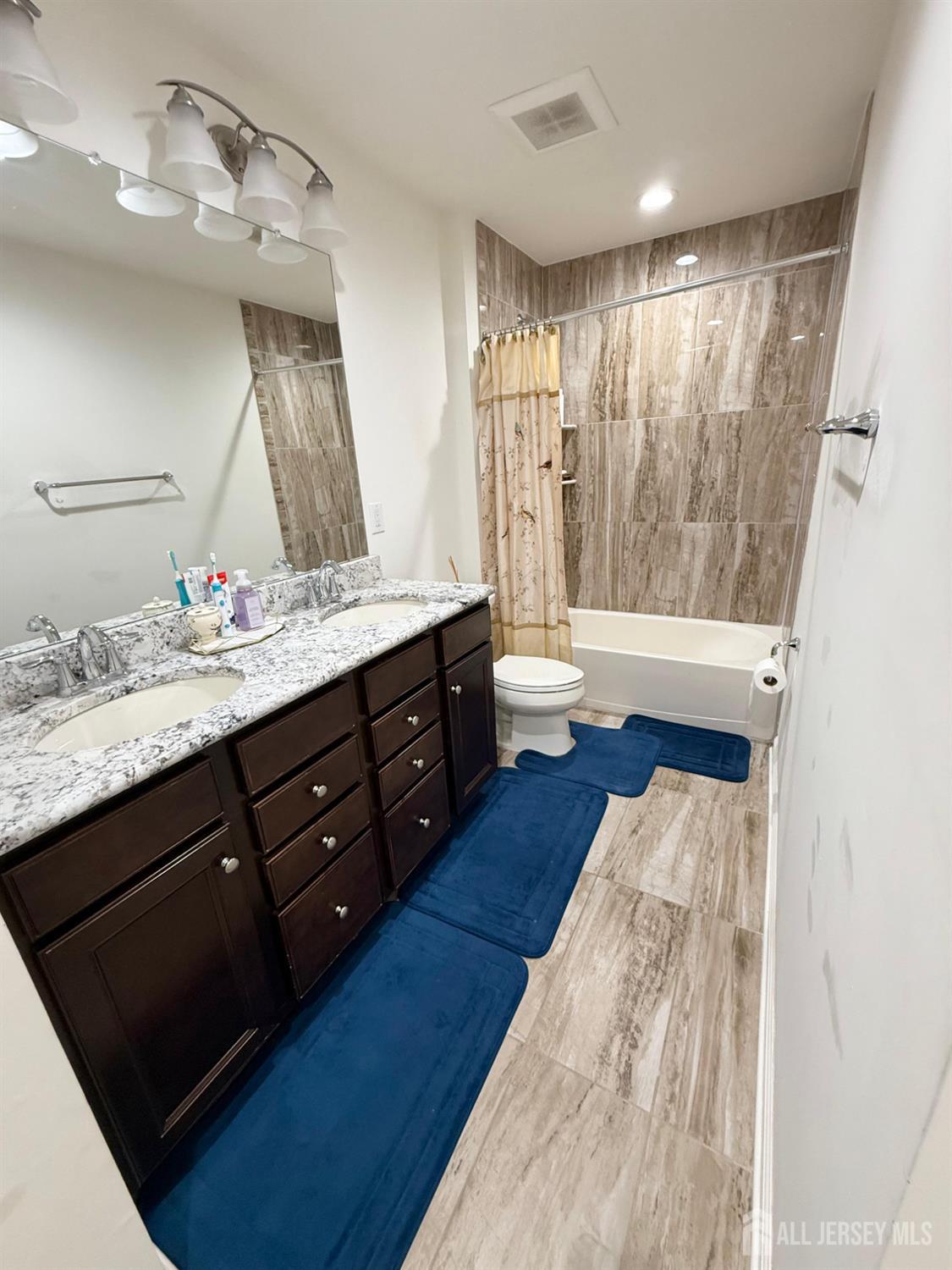 39 Periwinkle Drive, Unit 9 Monroe Township, NJ 08831 - Photo 15 of 26 a spacious bathroom with a double vanity sink a large mirror a bathtub and shower