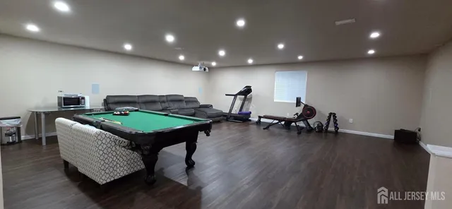 a room with furniture pool table and wooden floor