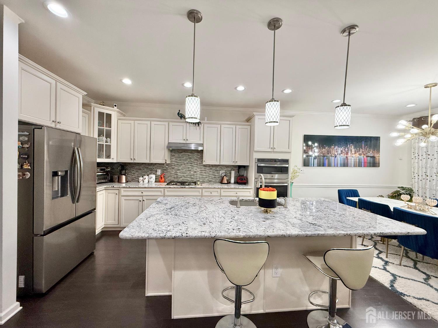 39 Periwinkle Drive, Unit 9 Monroe Township, NJ 08831 - Photo 4 of 26 a kitchen with stainless steel appliances granite countertop a sink a stove a refrigerator a center island and chairs