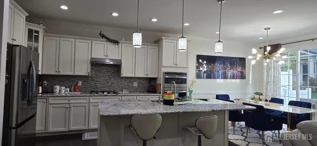 a kitchen with stainless steel appliances granite countertop a sink a stove a refrigerator and cabinets