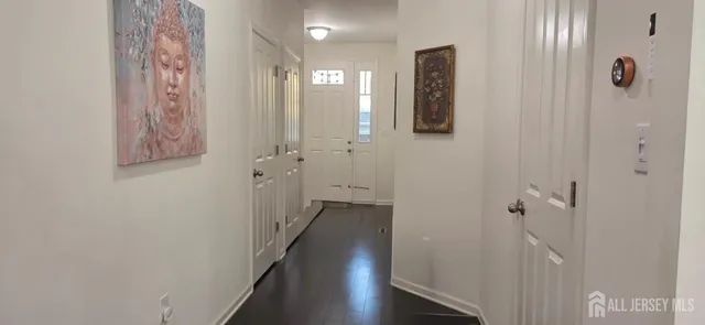 a view of a hallway with wooden floor and closet area